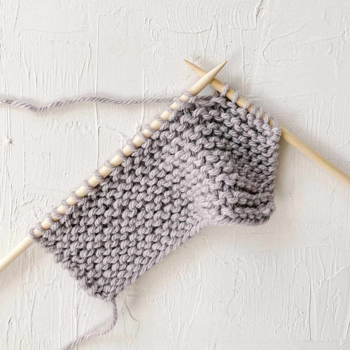 Knit stitches spread between two knitting needles.